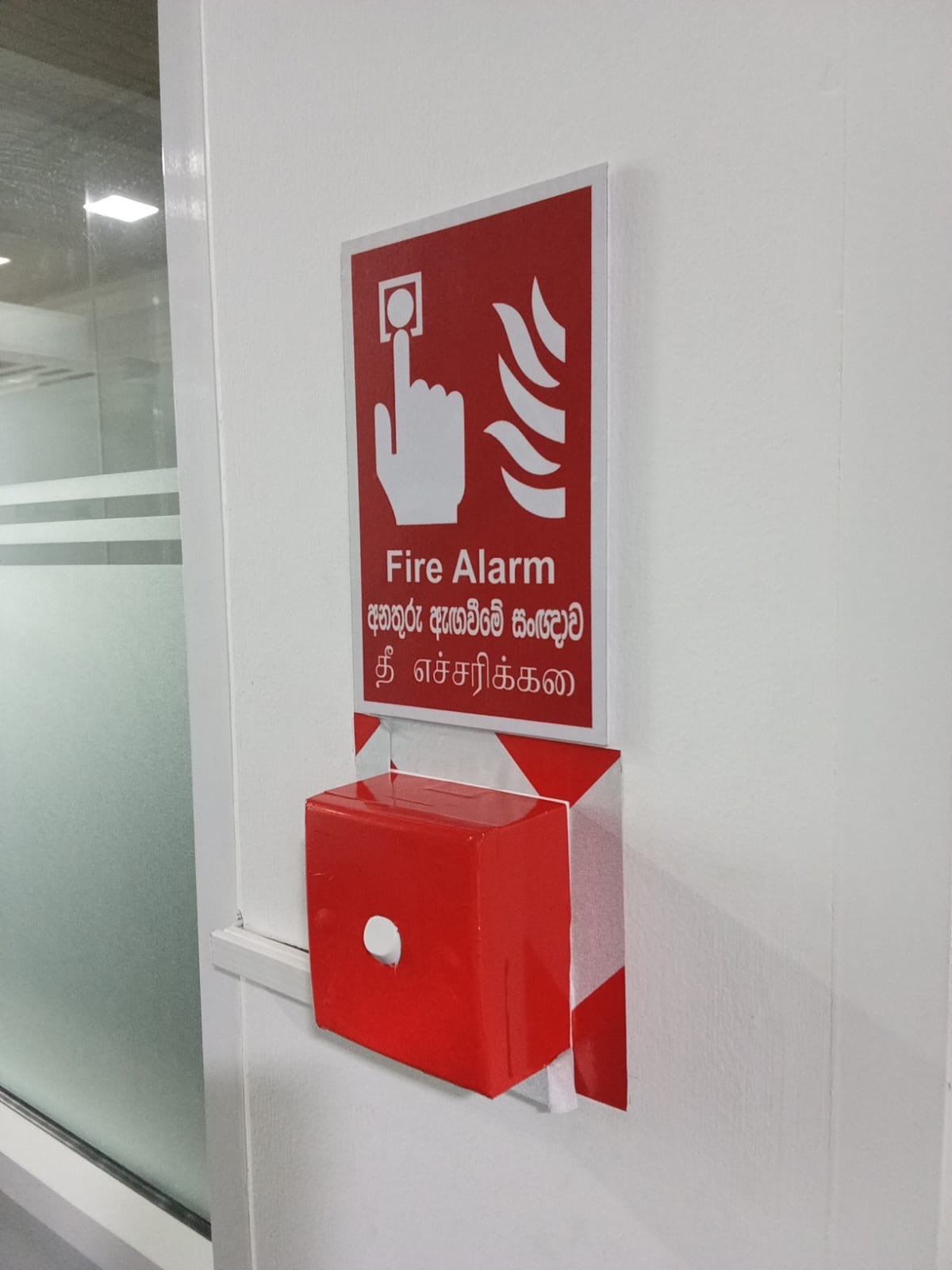 Manual break-glass fire alarm call point mounted on building pillar
